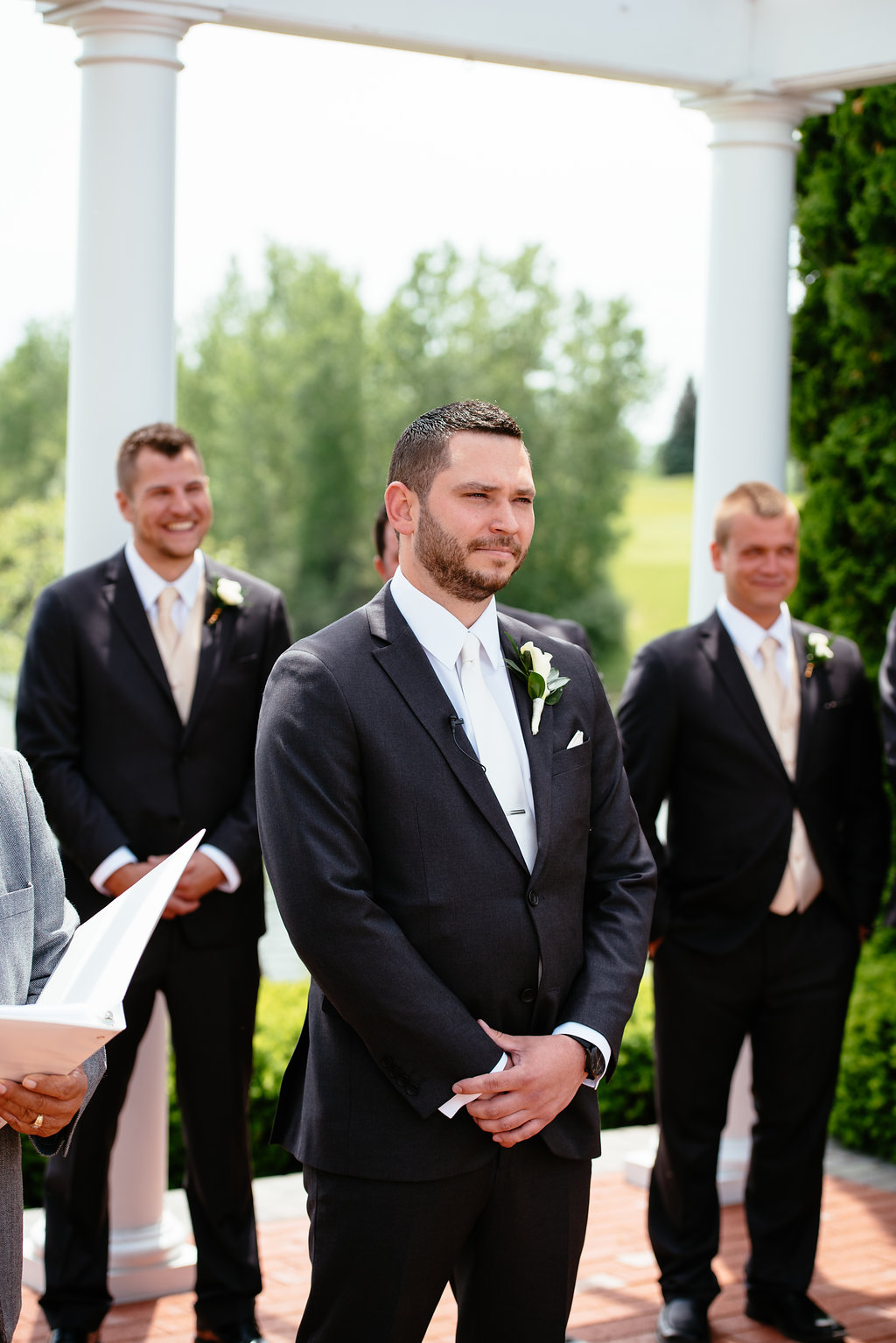 Groom watching bride walking down aisle